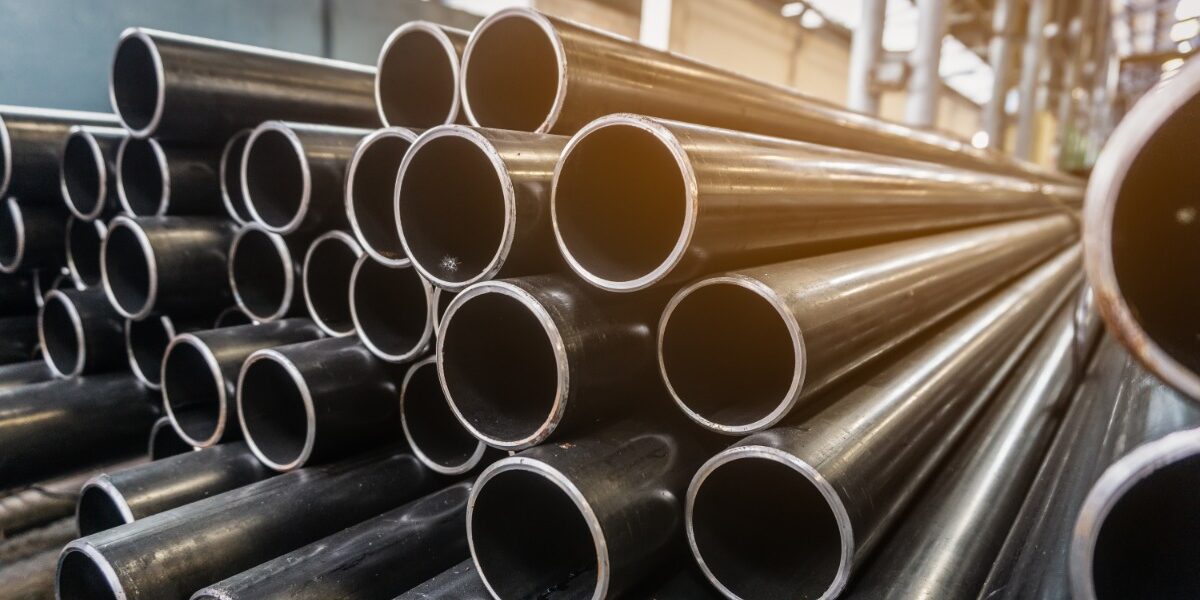 Stacks of round steel tubes are arranged horizontally. The open ends of the tubes face toward the viewer. Stacks of round steel tubes are arranged horizontally. The open ends of the tubes face toward the viewer.
