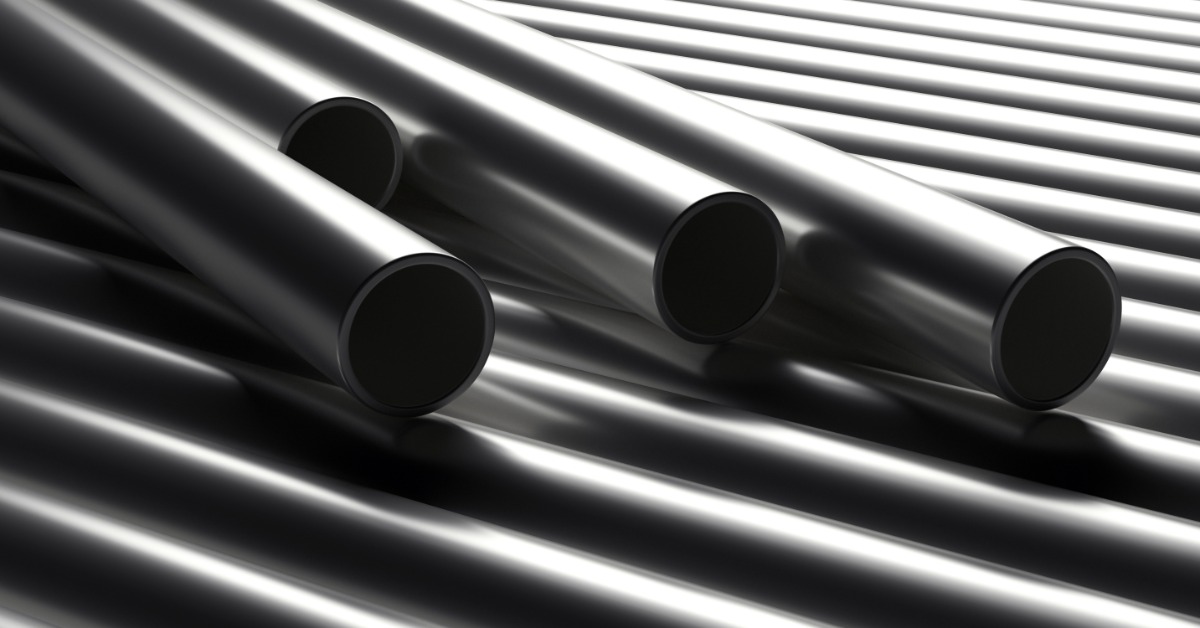 Four steel tubes lie atop more tubes arranged tightly side by side. The open ends of the four tubes face the viewer.